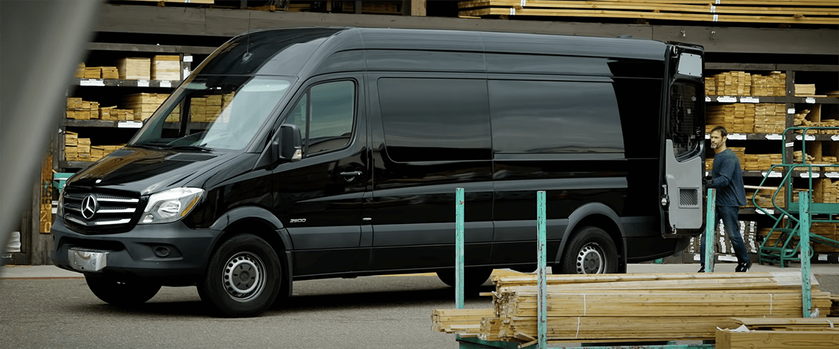 business owner loading lumber and tools into back of leased sprinter van