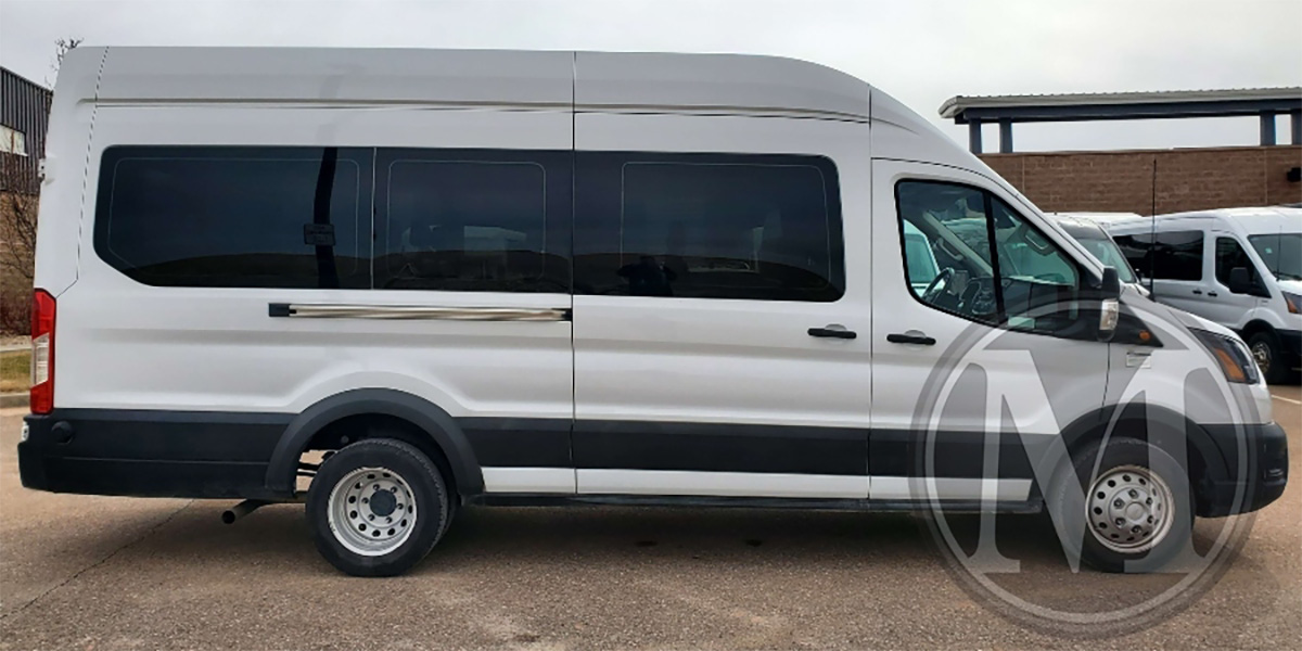 Exterior view of white 15 passenger Ford Transit commercial van