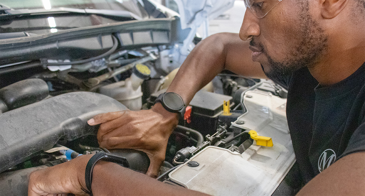 Maintenance technician inspecting engine inside shuttle bus