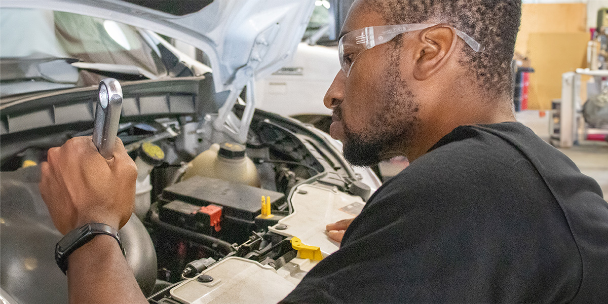 Bus mechanic making repairs to a used shuttle bus in Nebraska